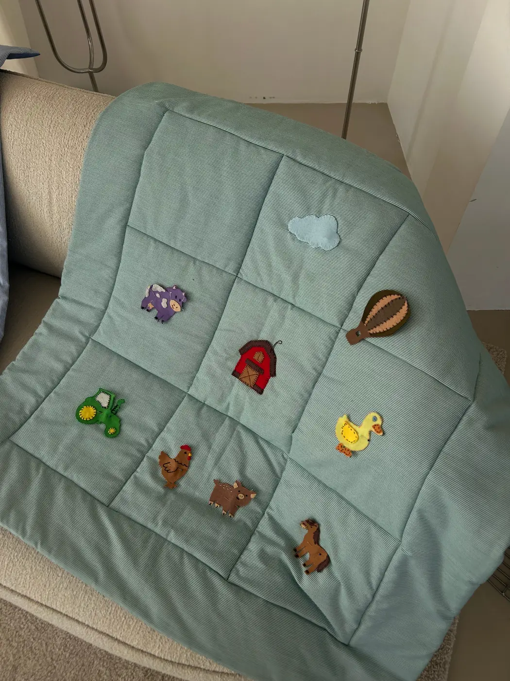 Green play mat with farm animal appliqués